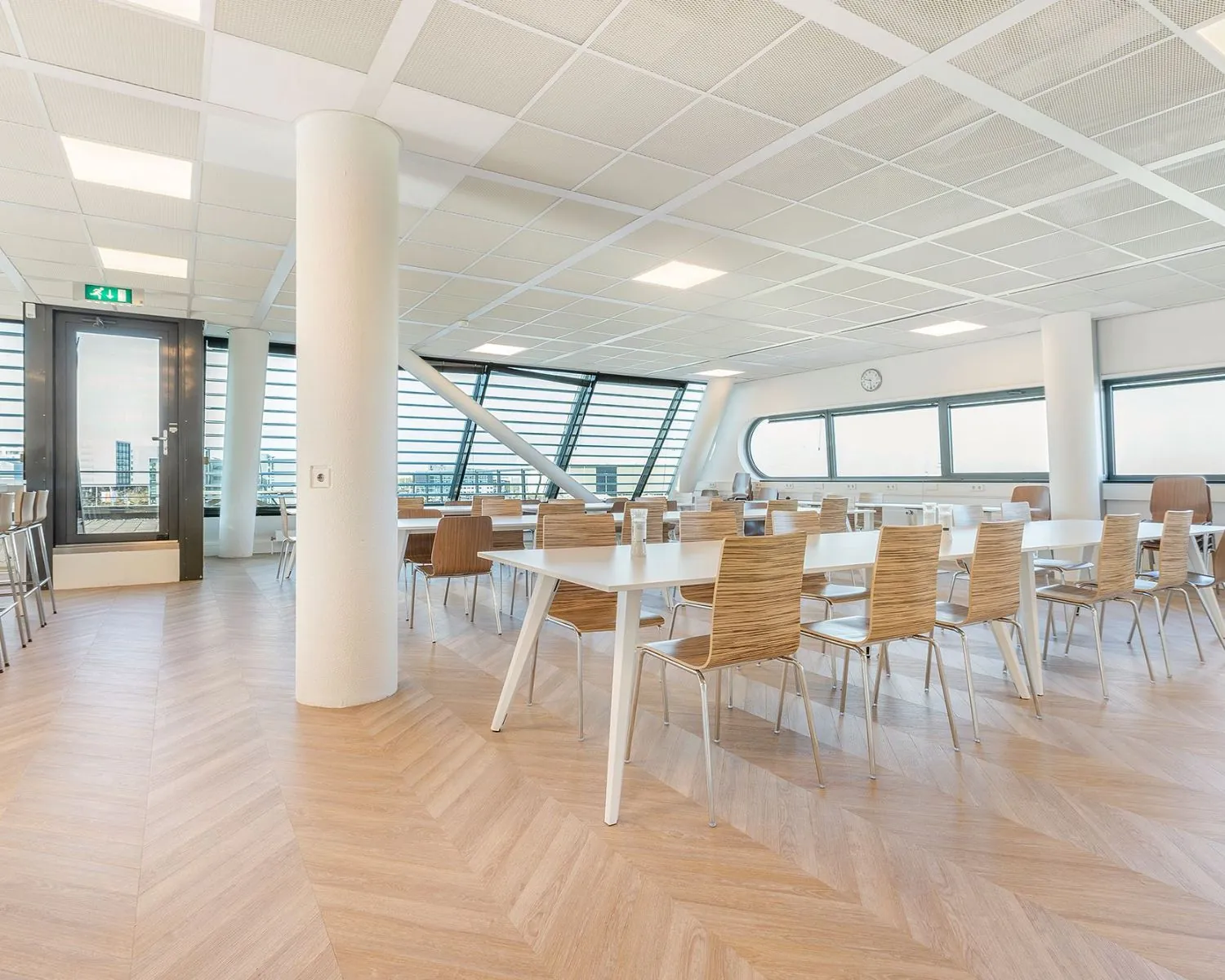 Moderne, lichte kantoorruimte met houten vloer, grote ramen en strakke inrichting op Stationsplein NO 438 in Schiphol-Oost.