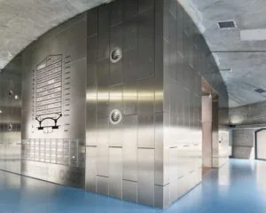 Moderne entreehal van kantoorgebouw Suikersilo Oost in SugarCity met metalen wanden en blauw vloeroppervlak.