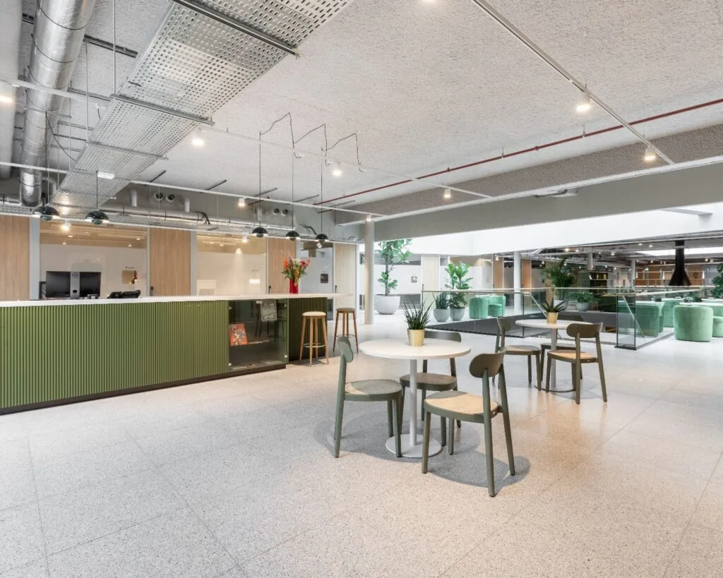 Moderne gemeenschappelijke kantoorruimte op Velperplein 23 in Arnhem met zitgedeelte, receptiebalie en groene accenten.