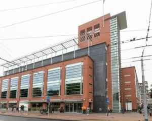 Moderne kantoorruimte aan het Velperplein 23 in Arnhem met roodstenen gevel en grote glazen ramen.