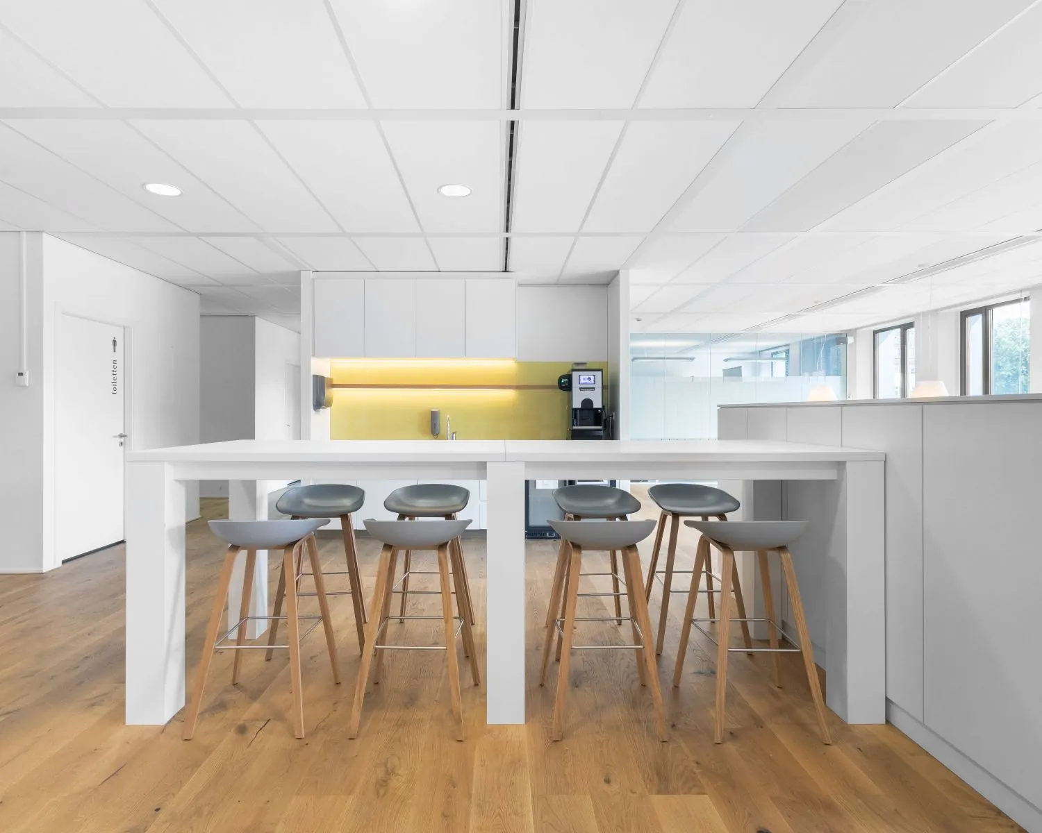 Moderne kantoorkeuken op Willemsplein 2 in Den Bosch met hoge tafel, barkrukken en koffiemachine.