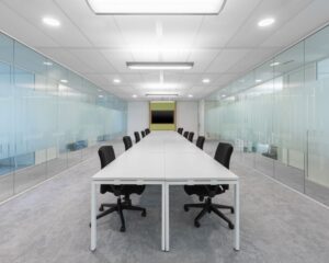 Moderne kantoorruimte aan het Willemsplein 2 in Den Bosch met lange vergadertafel, glazen wanden en bureaustoelen.