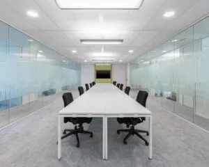 Moderne kantoorruimte aan het Willemsplein 2 in Den Bosch met lange vergadertafel, glazen wanden en bureaustoelen.