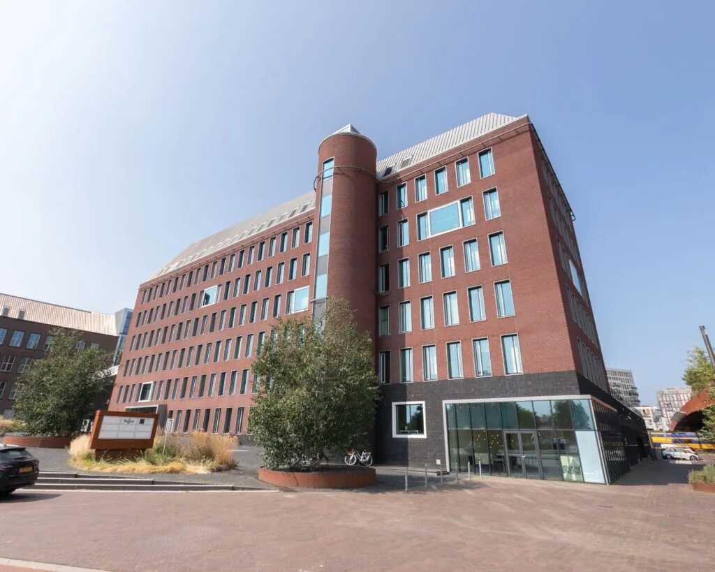 Modern kantoorgebouw aan het Willemsplein 2 in Den Bosch met rode bakstenen gevel en glazen entree.