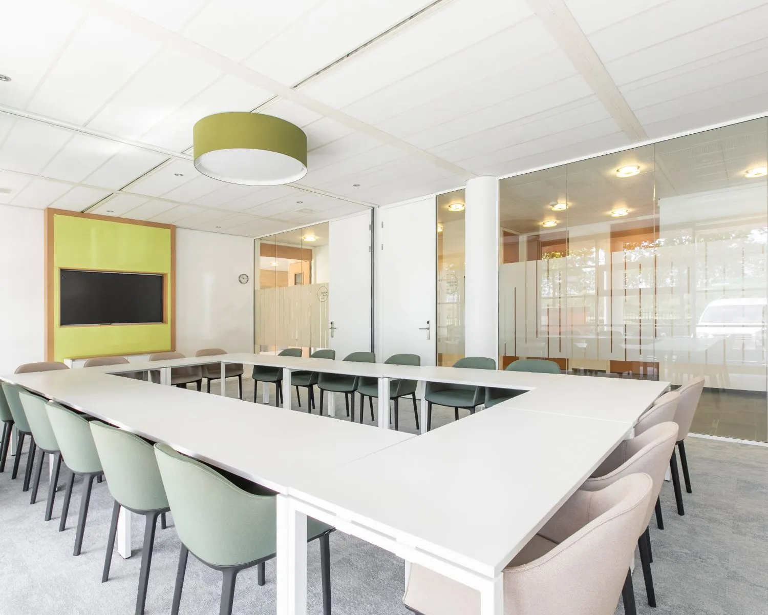 Moderne vergaderruimte in een kantoor aan de Databankweg 26 in Amersfoort met U-opstelling en glazen wanden.
