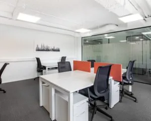 Moderne kantoorruimte met bureaus, bureaustoelen en glazen scheidingswand aan het Stationsplein 13A in Amersfoort.