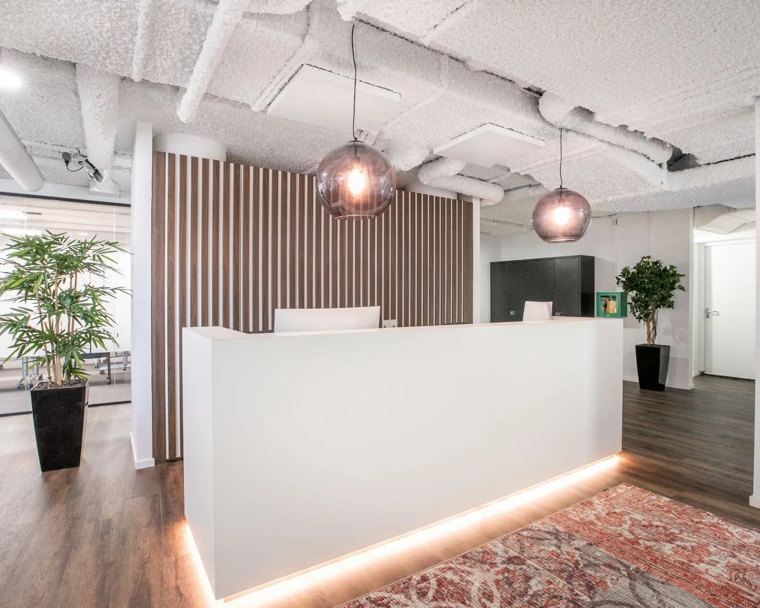 Moderne ontvangstbalie in een kantoorruimte aan het Stationsplein 13A in Amersfoort met houten accenten en sfeerverlichting.