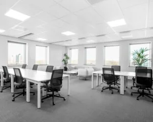 Moderne kantoorruimte te huur in de Queenstower aan de Delflandlaan in Amsterdam, met werkplekken, bureaustoelen en grote ramen.