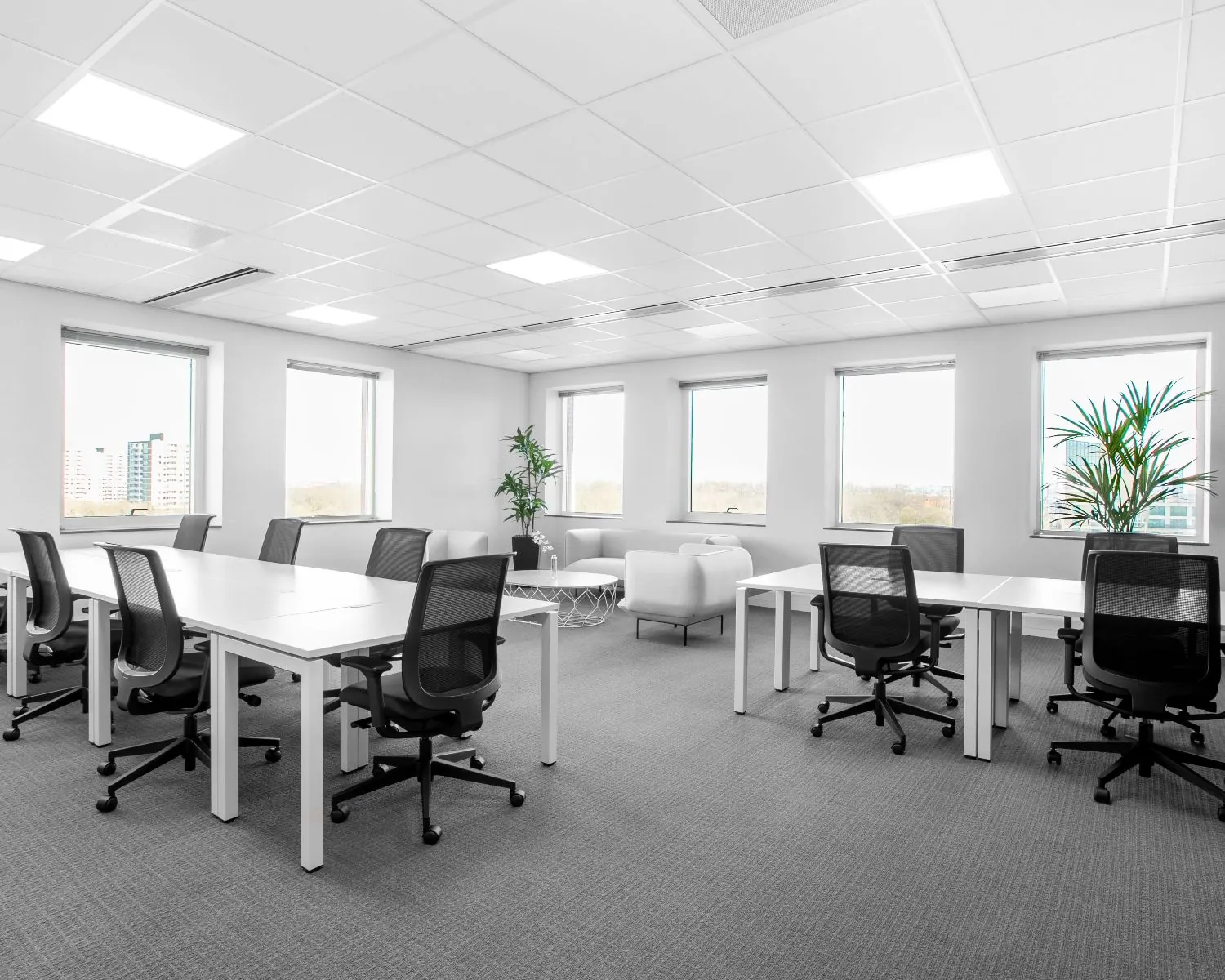 Moderne kantoorruimte te huur in de Queenstower aan de Delflandlaan in Amsterdam, met werkplekken, bureaustoelen en grote ramen.