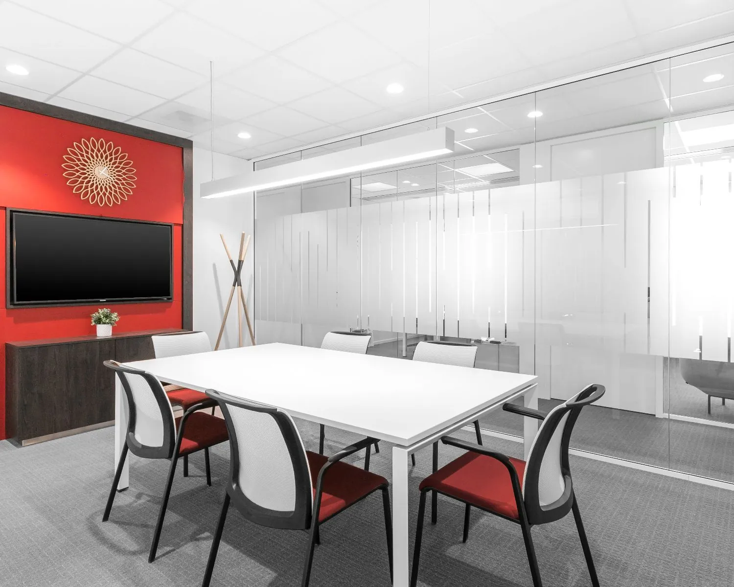 Moderne vergaderruimte in de Queenstower aan de Delflandlaan in Amsterdam met glazen wanden, rode accenten en een flatscreen.