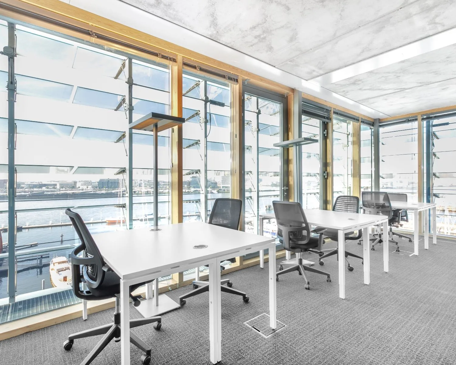 Moderne kantoorruimte te huur aan Kraanspoor 50 in Amsterdam met werkplekken en uitzicht op het water.