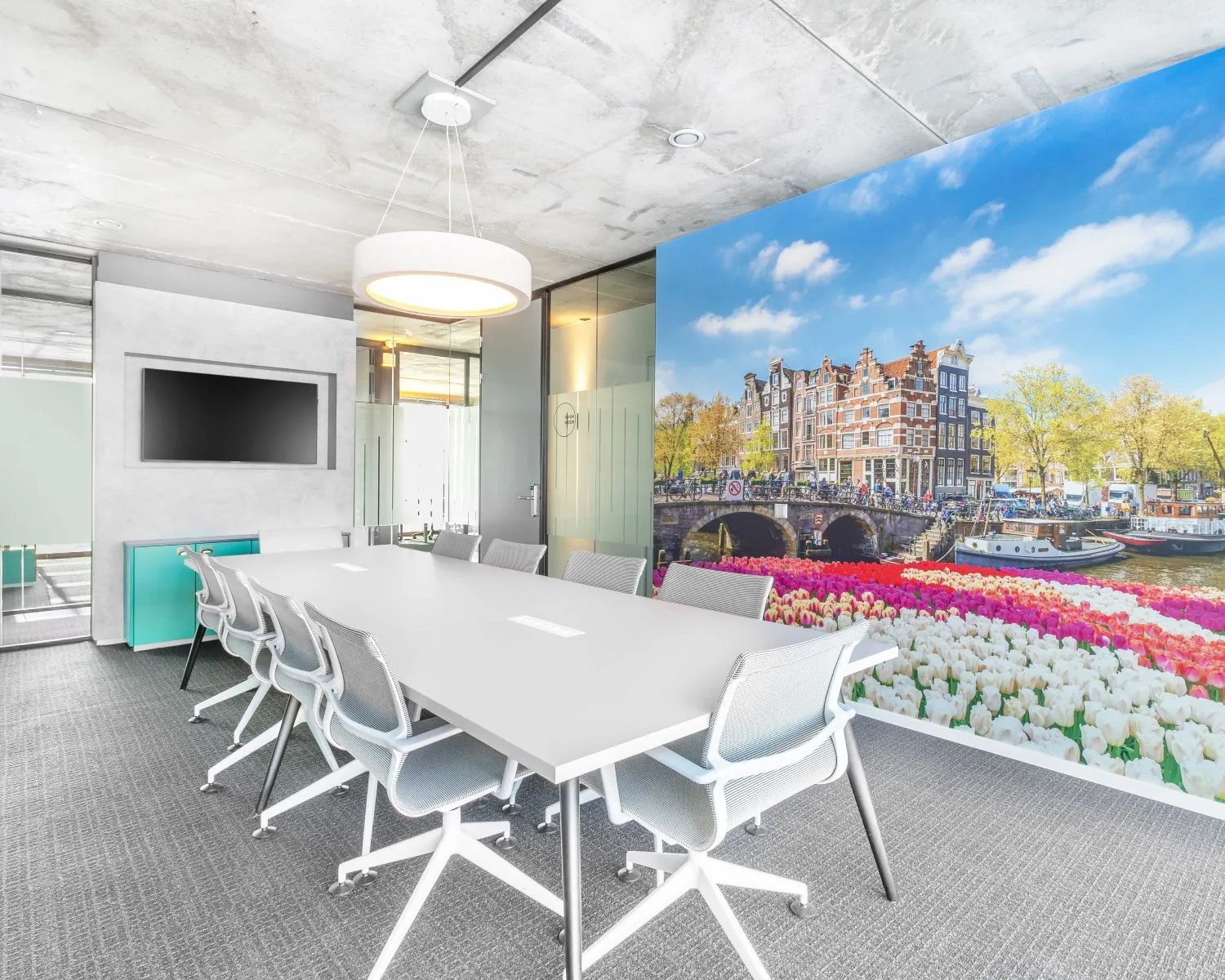 Moderne vergaderruimte in kantoor aan de Kraanspoor 50 in Amsterdam met een opvallende muurafbeelding van grachtenpanden en tulpen.