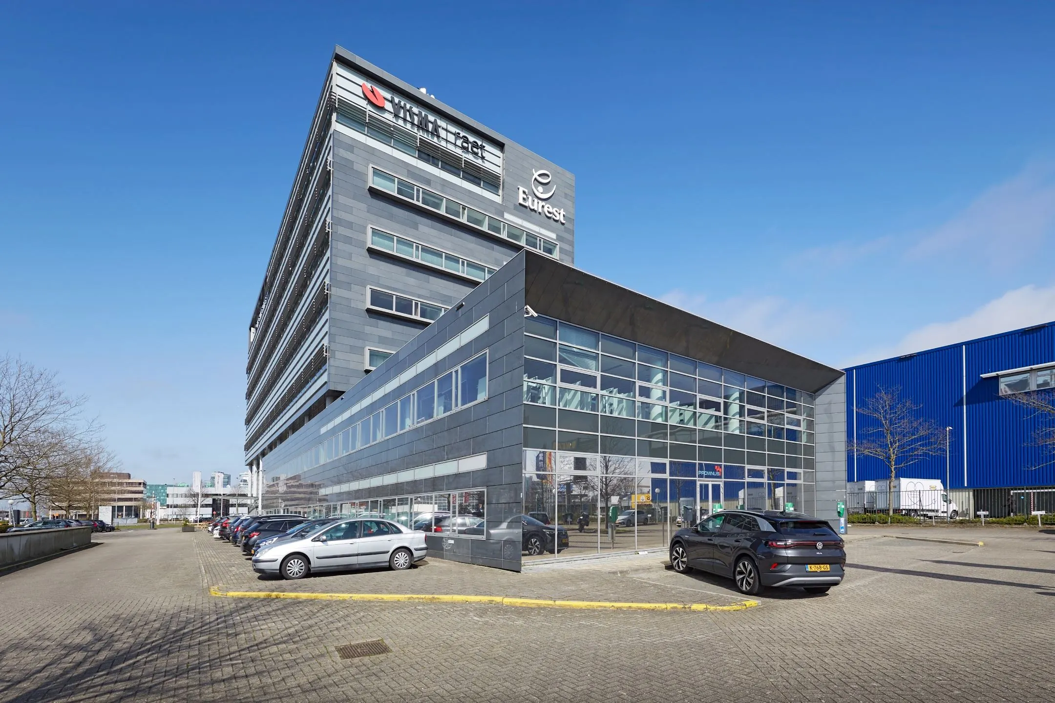 Modern kantoorgebouw aan de Laarderhoogtweg 7-11 in Amsterdam met parkeerplaatsen voor de deur.