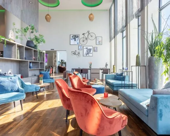 Lichte en moderne kantoorruimte met kleurrijke zitmeubels in het Leonardo Royal Hotel aan de Paul van Vlissingenstraat 24 in Amsterdam.
