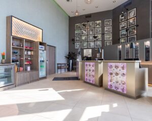 Moderne receptieruimte in het Leonardo Royal Hotel aan de Paul van Vlissingenstraat 24 in Amsterdam met displays, foto's en een minimarkt.