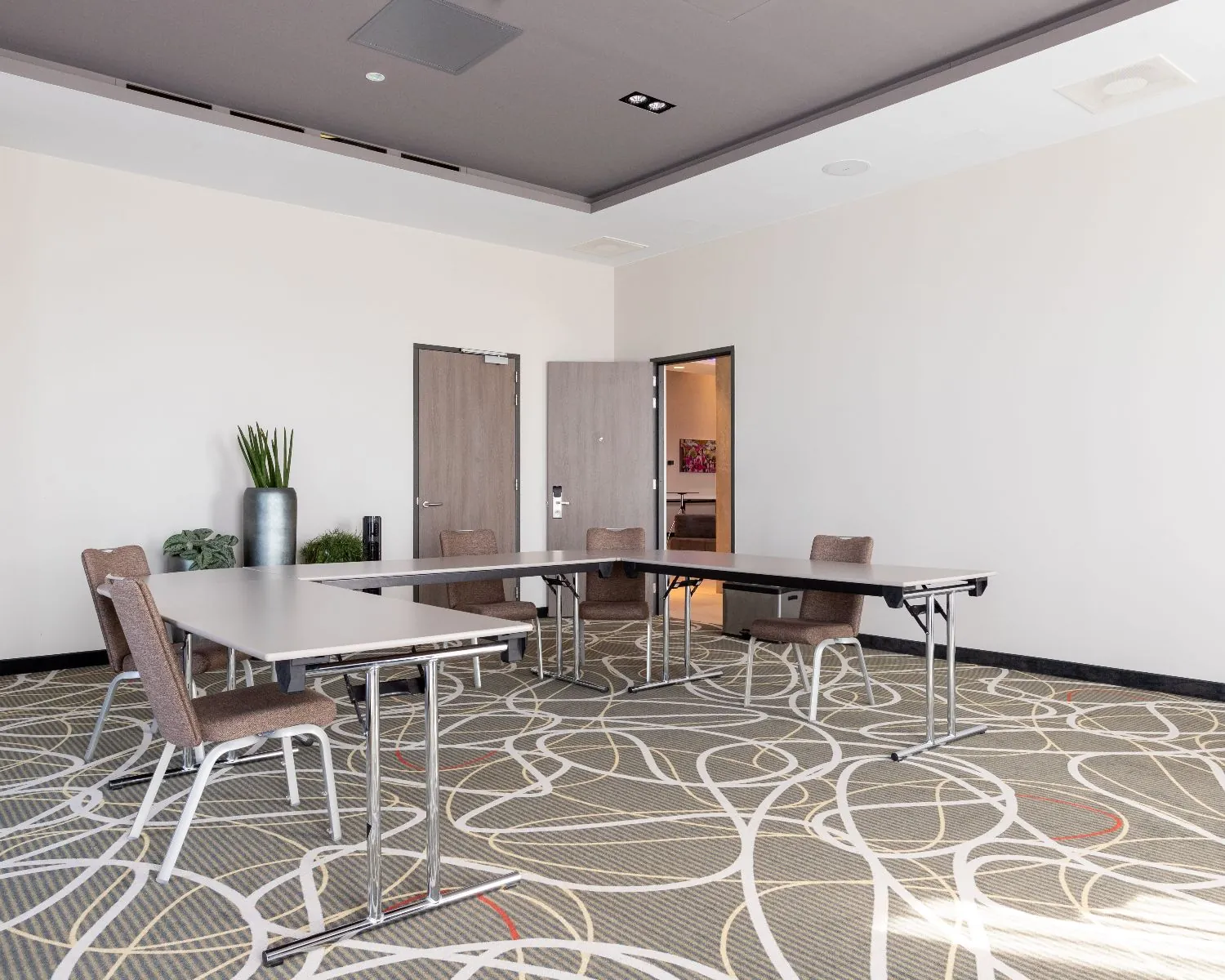 Vergaderruimte met moderne inrichting en vergadertafels in het Leonardo Royal Hotel aan de Paul van Vlissingenstraat 24 in Amsterdam.