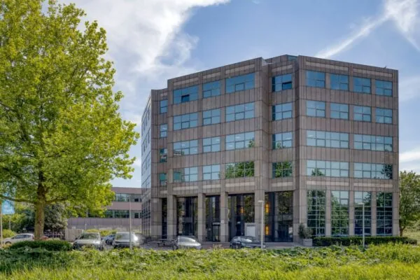 Zakelijk kantoorgebouw aan de Overschiestraat 186 in Amsterdam met meerdere verdiepingen en parkeerplaatsen voor de deur.