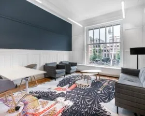 Moderne kantoorruimte aan het Rokin in Amsterdam met zithoek, grote raampartij en opvallend vloerkleed.