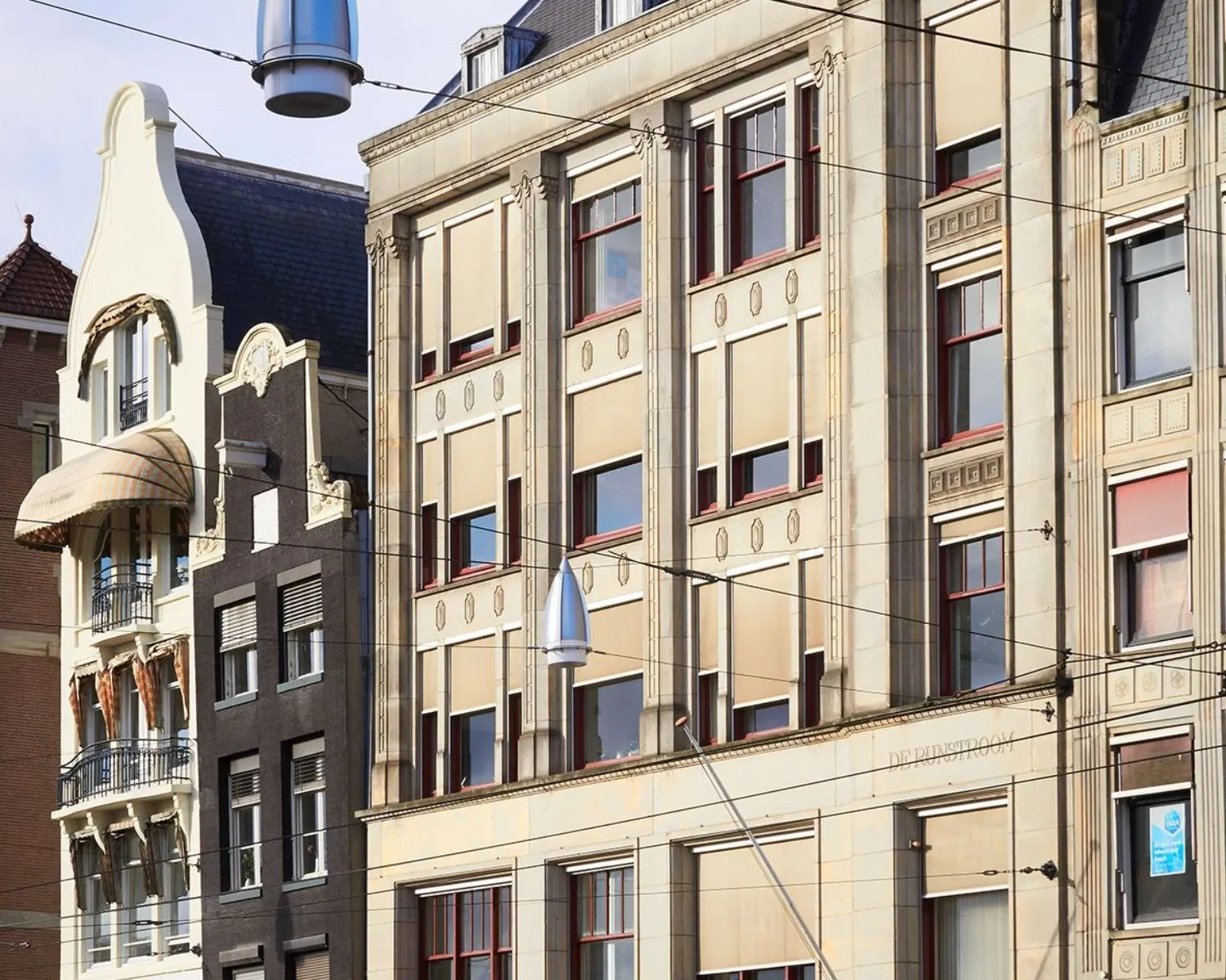 Voorgevel van het kantoorgebouw aan Rokin 10 in Amsterdam met omliggende panden en bovenleidingen van de tram.