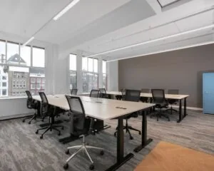 Moderne kantoorruimte met werkplekken en uitzicht op het Rokin in Amsterdam.