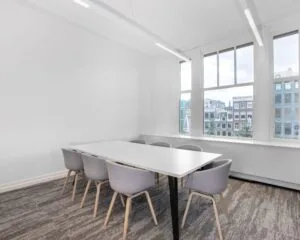 Moderne vergaderruimte met grote ramen en uitzicht op het Rokin in Amsterdam.