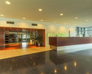 Moderne entreehal met receptiebalie in het kantoorpand aan de Avenue Céramique 221.