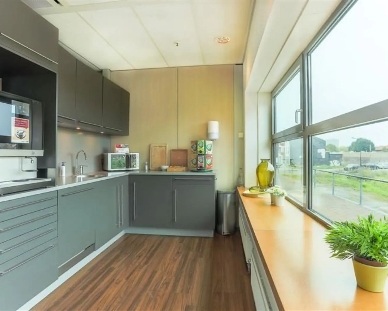 Moderne pantry in kantoorruimte aan de Avenue Céramique 221 met uitzicht op de omgeving.