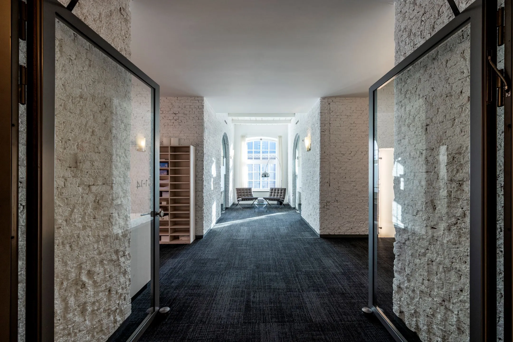 Lichte, moderne kantoorruimte met bakstenen muren en zitgedeelte bij het raam in De Bell aan de Sarphatistraat 370.