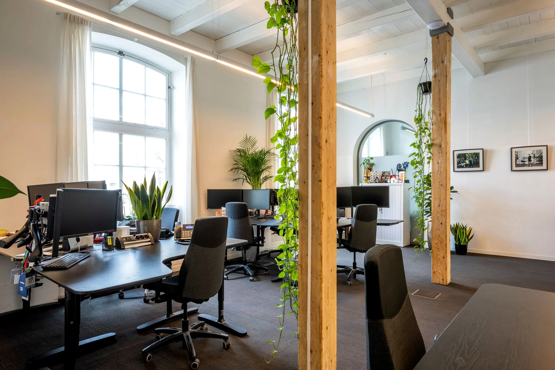 Moderne, lichte kantoorruimte te huur aan de Sarphatistraat 370 met open werkplekken, planten en houten details.