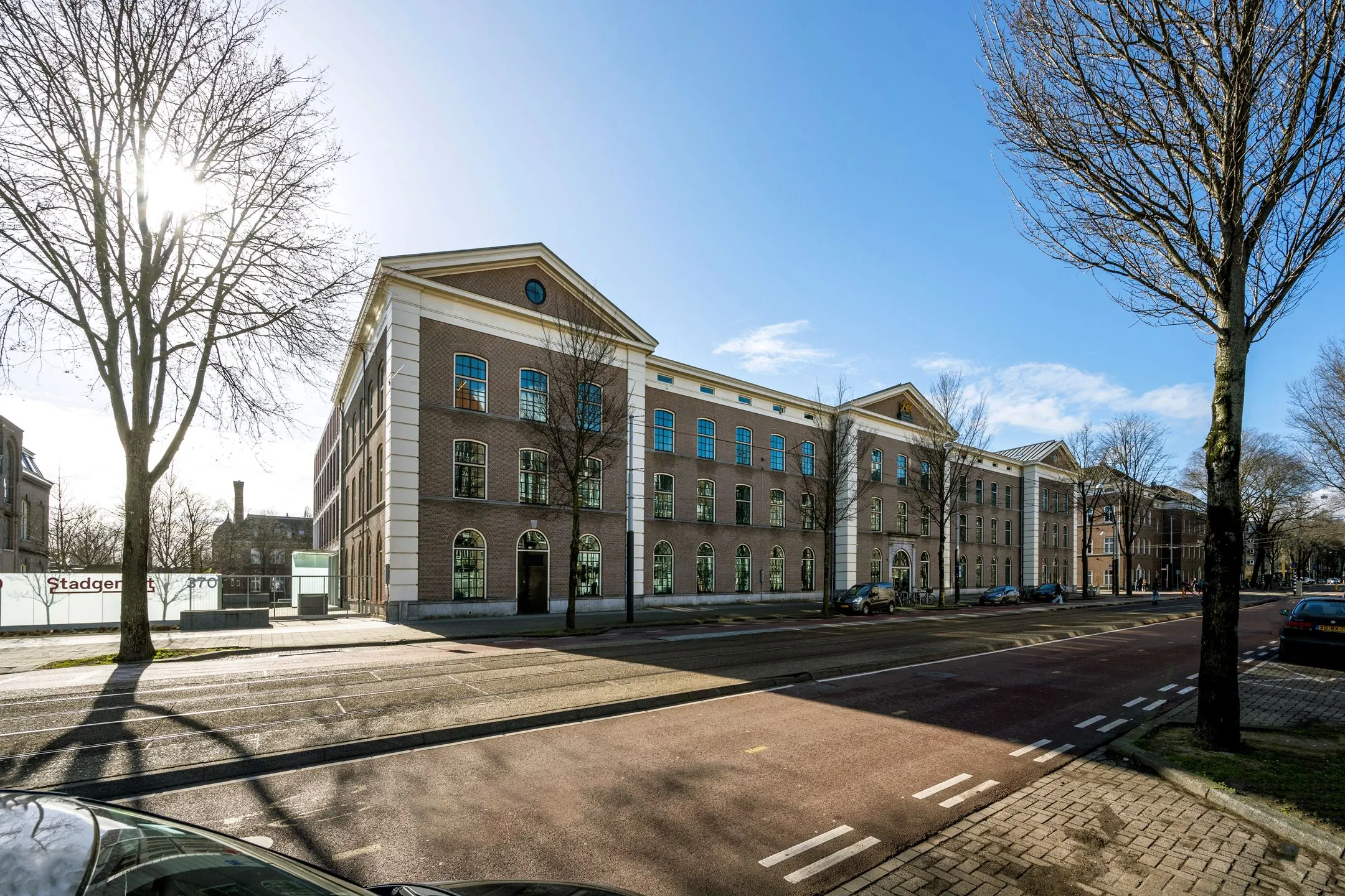 Vooraanzicht van kantoorpand De Bell aan de Sarphatistraat 370 in Amsterdam op een zonnige dag.