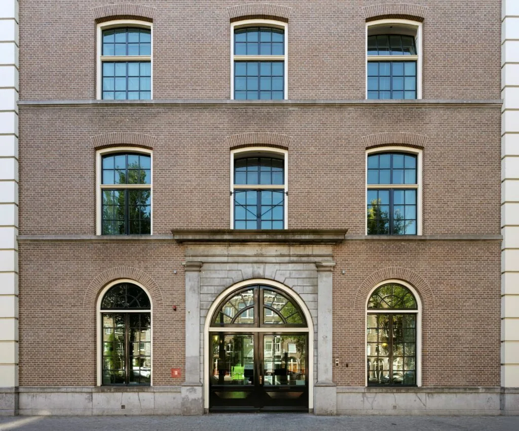 Voorgevel van het kantoorgebouw De Bell aan de Sarphatistraat 370 met grote ramen en een klassieke entree.