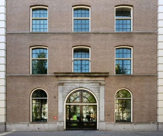 Voorgevel van het kantoorgebouw De Bell aan de Sarphatistraat 370 met grote ramen en een klassieke entree.