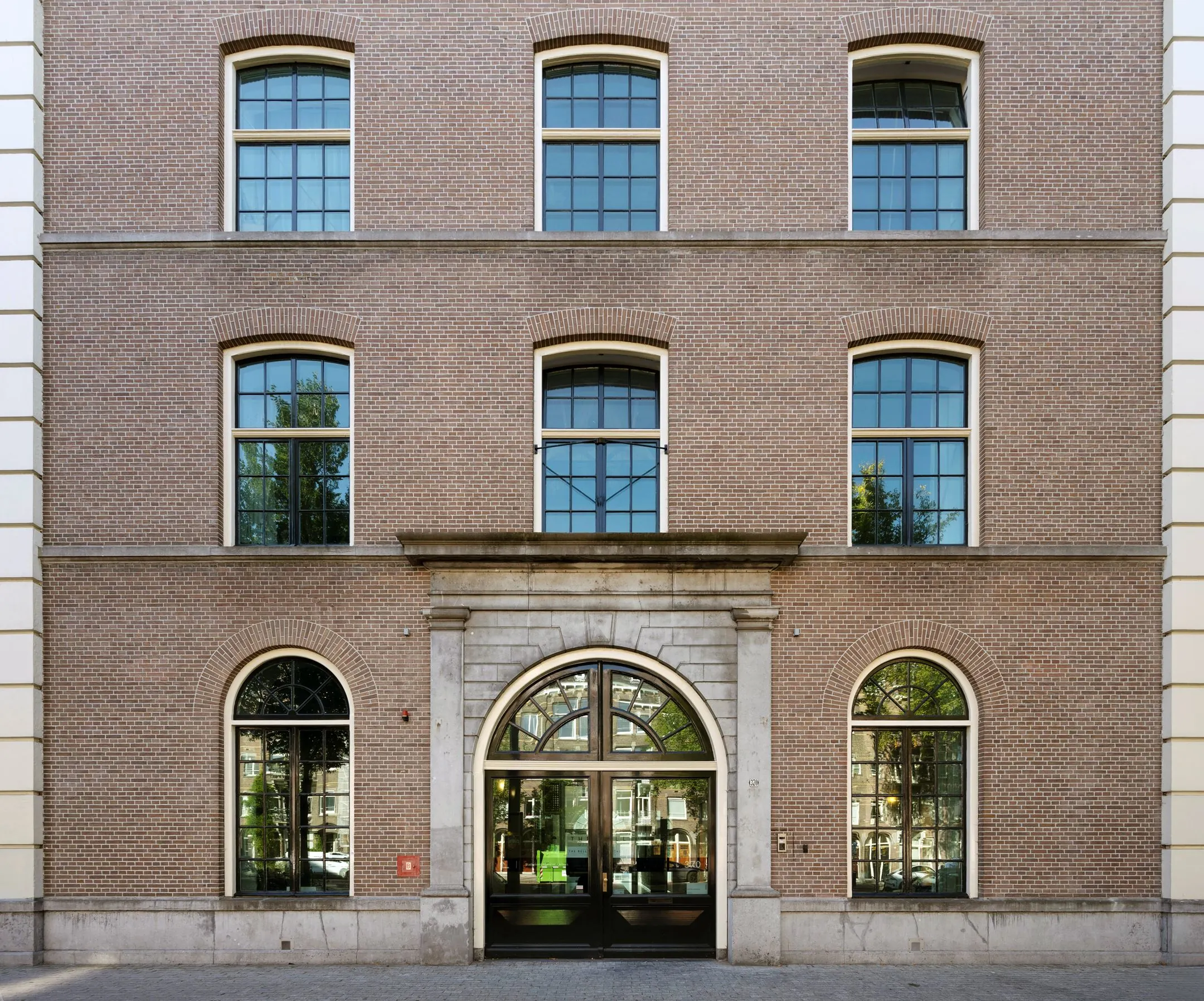 Voorgevel van het kantoorgebouw De Bell aan de Sarphatistraat 370 met grote ramen en een klassieke entree.