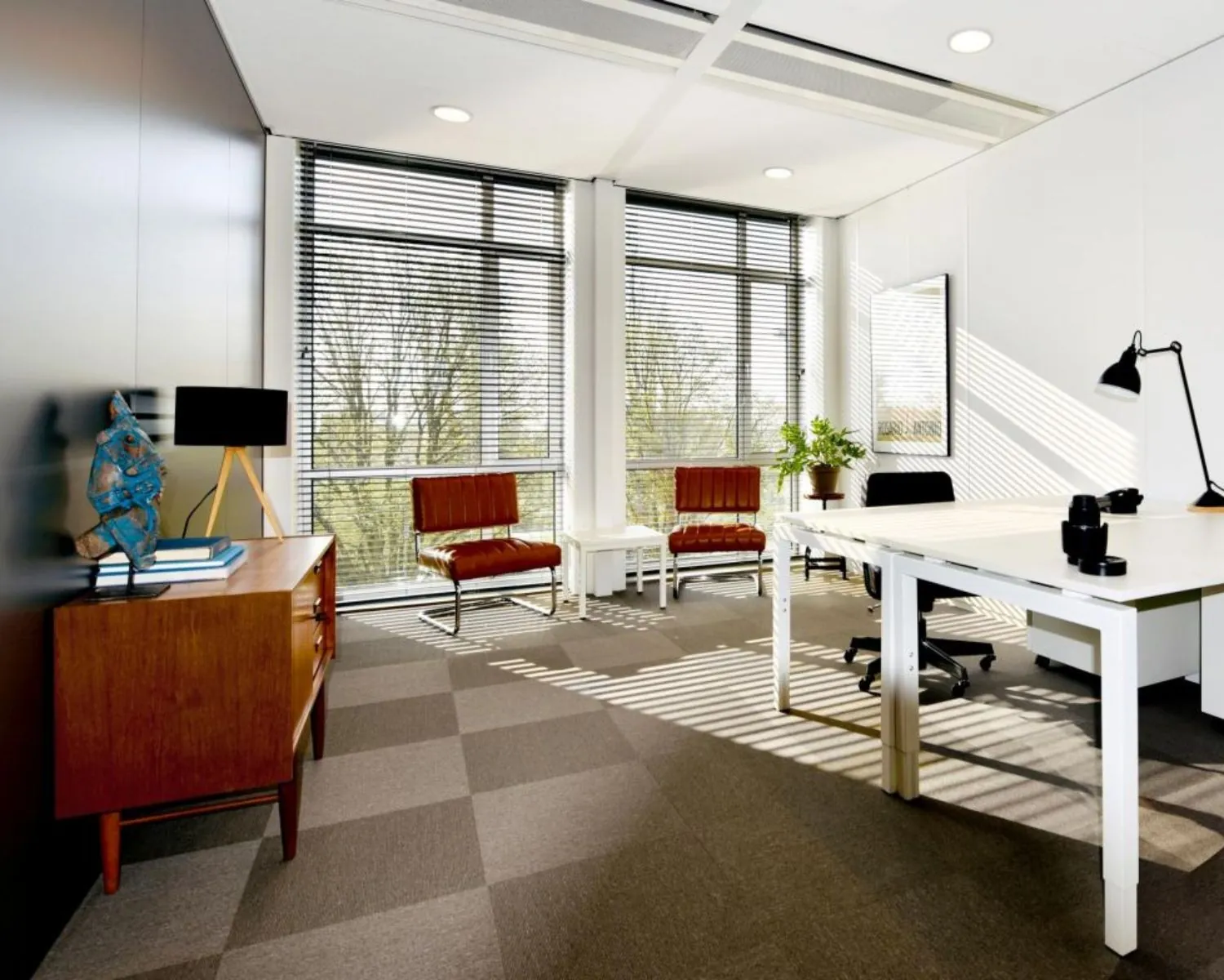 Moderne, lichte kantoorruimte te huur aan de President Kennedylaan 19 in Den Haag met grote ramen, strak meubilair en een rustige uitstraling.