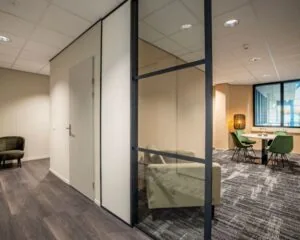 Moderne kantoorruimte te huur aan de Europalaan 4 in Den Bosch met glazen scheidingswanden, groene stoelen en strak interieur.