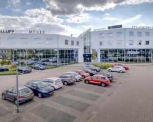 Moderne kantoorruimte aan de Europalaan 6 in Den Bosch met parkeergelegenheid en bedrijfsnamen zichtbaar op de gevel.