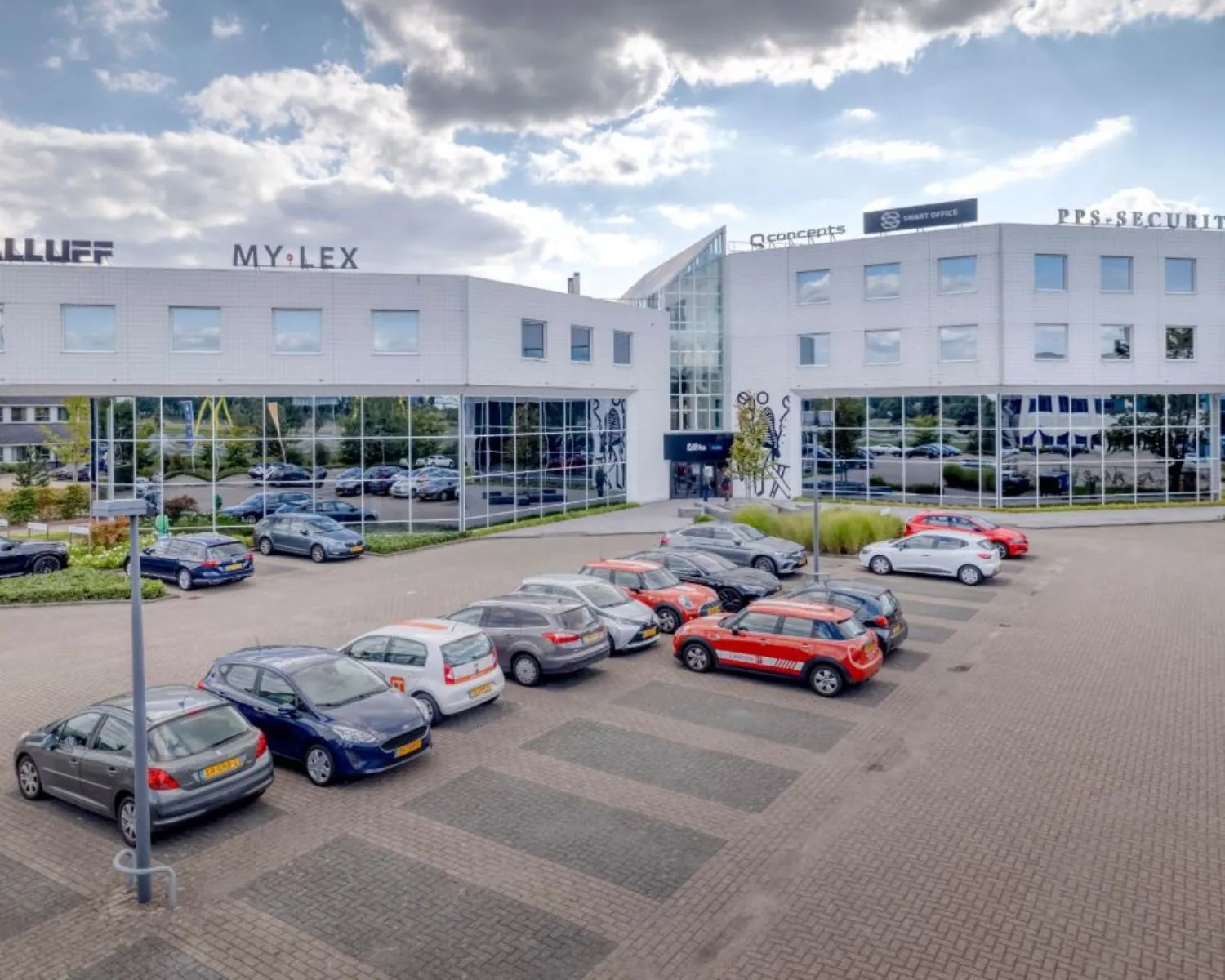 Moderne kantoorruimte aan de Europalaan 6 in Den Bosch met parkeergelegenheid en bedrijfsnamen zichtbaar op de gevel.