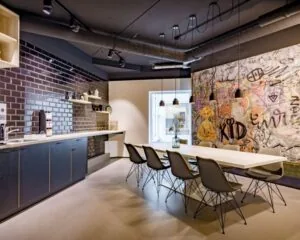 Moderne kantoorruimte aan de Europalaan 6 in Den Bosch met open keuken, lange vergadertafel en kleurrijke graffiti-muur.
