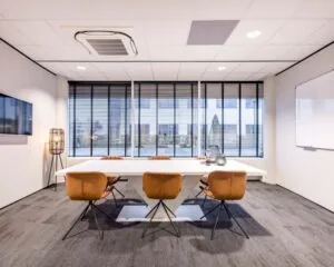Moderne vergaderruimte met grote tafel, leren stoelen en uitzicht op de buitenzijde van Europalaan 6 in Den Bosch.