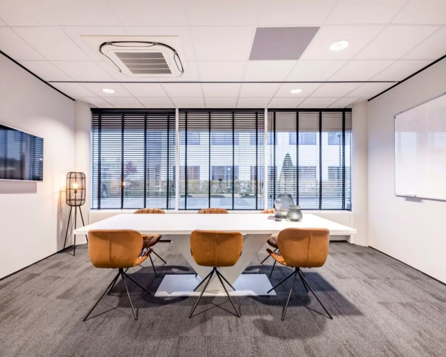 Moderne vergaderruimte met grote tafel, leren stoelen en uitzicht op de buitenzijde van Europalaan 6 in Den Bosch.