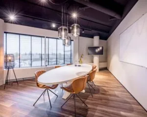 Moderne vergaderruimte met ovale tafel, leren stoelen en grote ramen in kantoor aan de Europalaan 6 in Den Bosch.