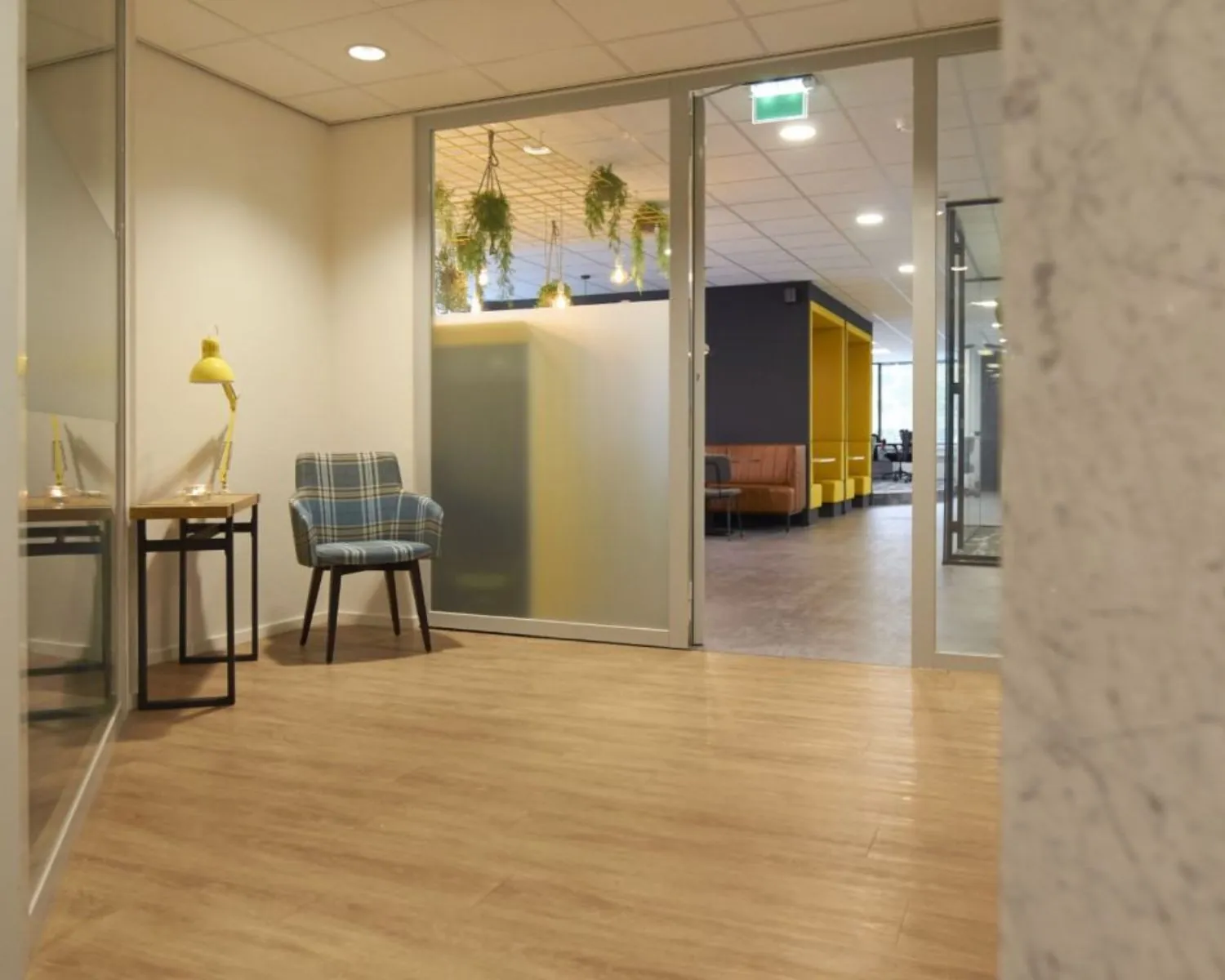 Moderne kantoorruimte aan Fellenoord 200-240 in Eindhoven met glazen wanden, houten vloer en kleurrijke inrichting.