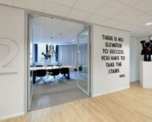 Moderne kantoorruimte in Eindhoven met vergaderruimte, kunstobjecten en een motiverende quote op de muur.
