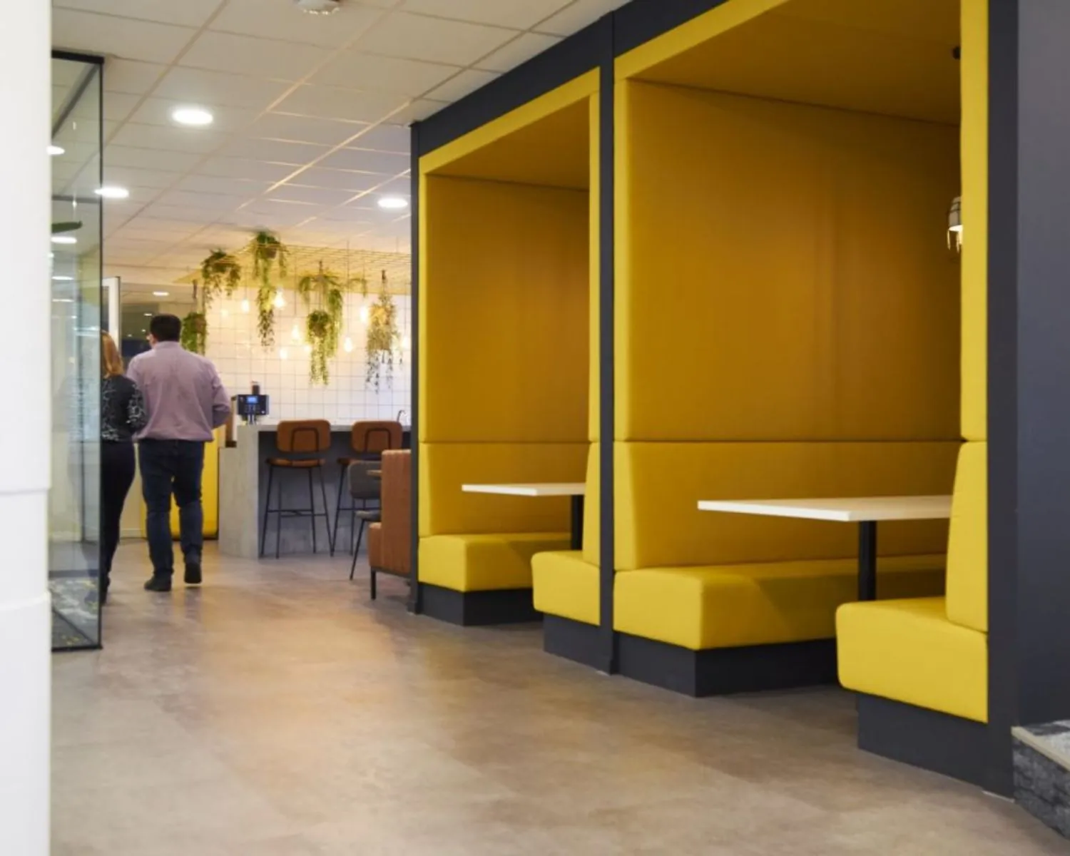 Moderne kantoorruimte in Eindhoven met gele zitnissen en een sfeervolle koffiehoek.