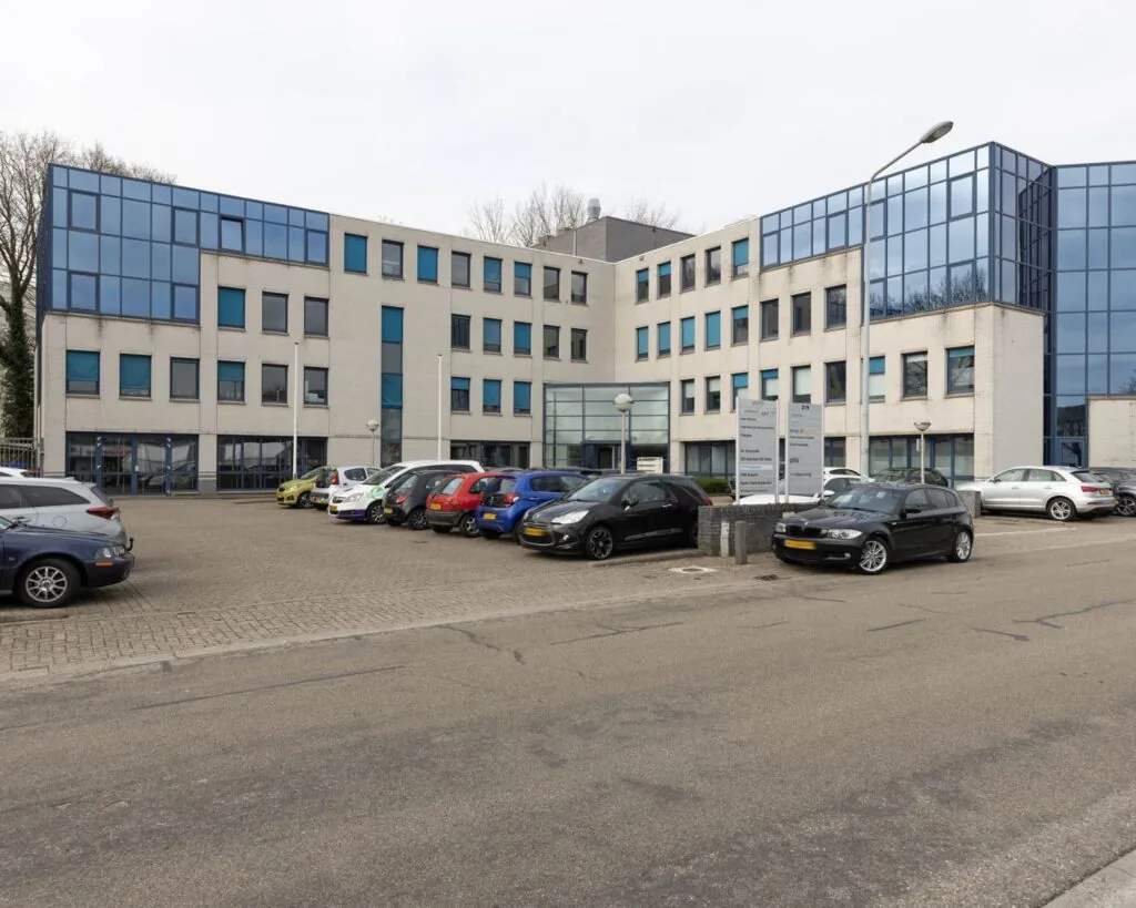 Modern kantoorgebouw aan de Franciscusweg 219 in Hilversum met parkeerplaatsen aan de voorzijde.