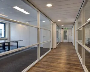 Moderne kantoorruimte met glazen wanden en houten vloer aan de Franciscusweg 219 in Hilversum.
