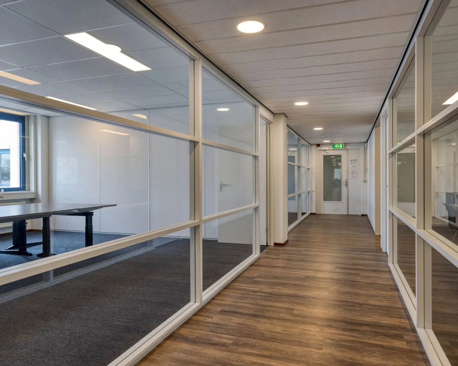 Moderne kantoorruimte met glazen wanden en houten vloer aan de Franciscusweg 219 in Hilversum.