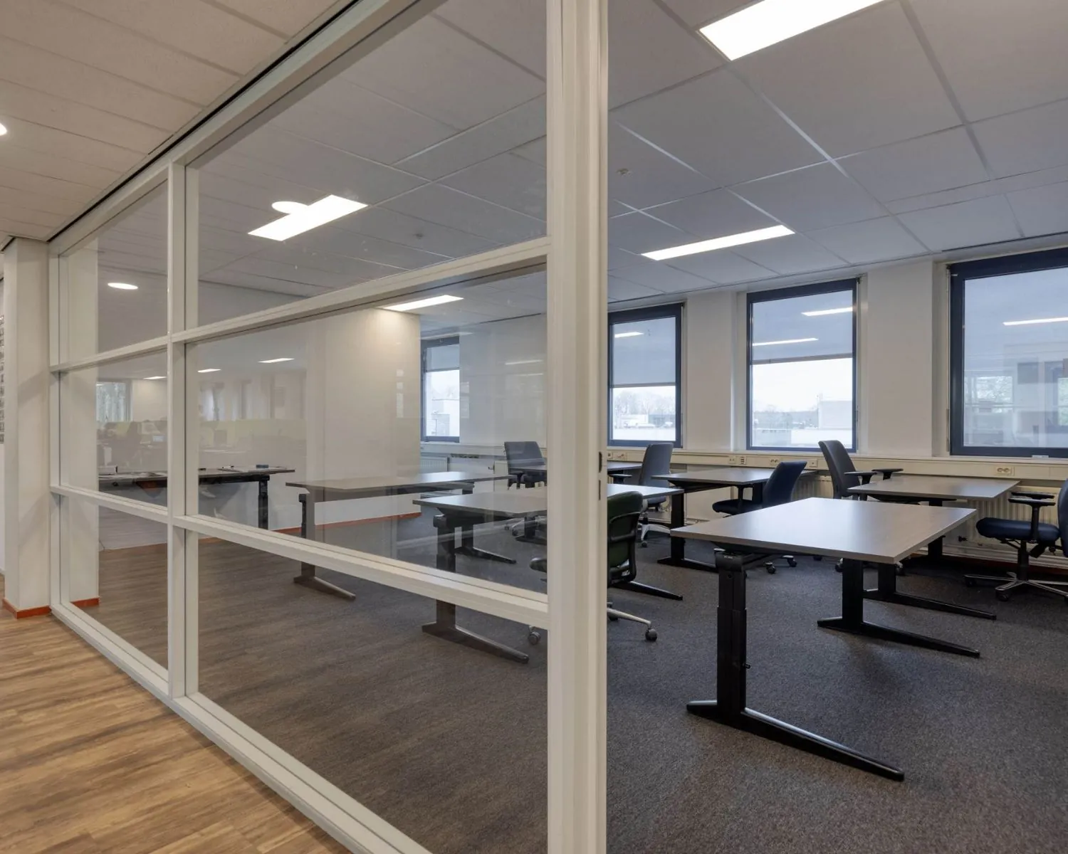 Moderne kantoorruimte te huur aan de Franciscusweg 219 in Hilversum met meerdere werkplekken en grote ramen.