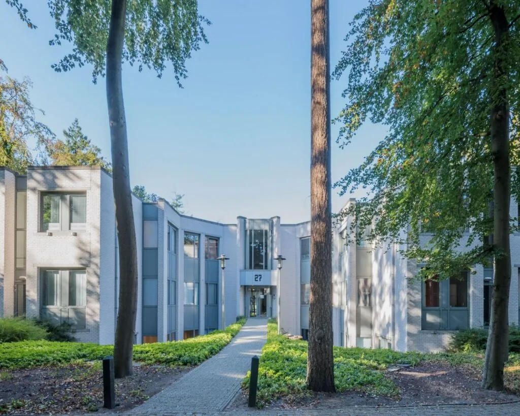 Moderne kantoorruimte aan de Mozartlaan 27 in Hilversum, omgeven door groen en bomen.