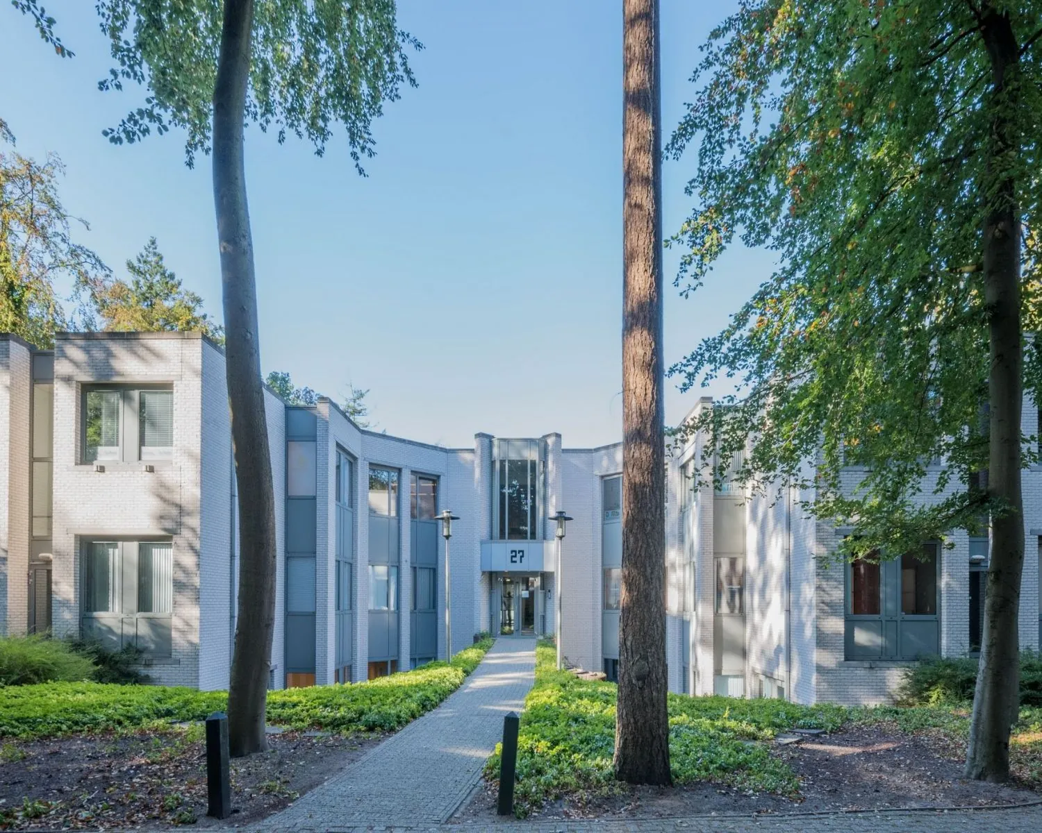 Moderne kantoorruimte aan de Mozartlaan 27 in Hilversum, omgeven door groen en bomen.